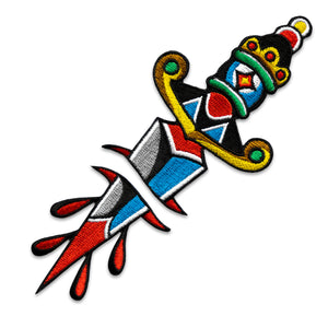 "Dagger" two-part embroidered iron-on patch designed by Brandon Ing. Patch is of traditional tattoo flash drawing of a dagger, split into two halves.  One half is the blade, and the other half is the handle.  Patch is multi colored, photographed against a white background.
