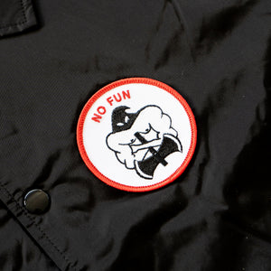 Close up image of the black, red, and white executioner patch that is found on the breast of the "NO FUN®" X "Crawling Death" jacket.  The patch also features a red "NO FUN®" logo.  This detail image also showcases the snap button closure.