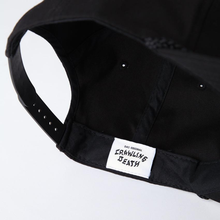 Photo of the "NO FUN®" X "Crawling Death" collaboration black, strapback hat. The hat features a white patch with red embroidered border. The embroidered graphic on the patch is a black and white executioner, with red "NO FUN®" logo.  The photo shoes the inside "Crawling Death" logo.
